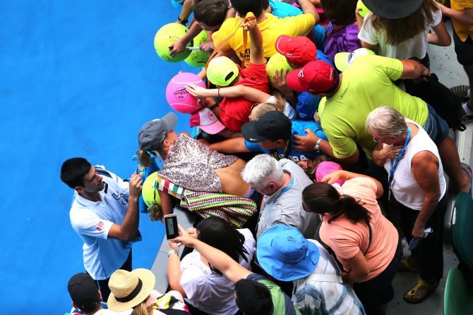 Despite the hot temperatures, Djokovic stayed on court to sign autographs. He's bidding for a fifth Australian Open title. 