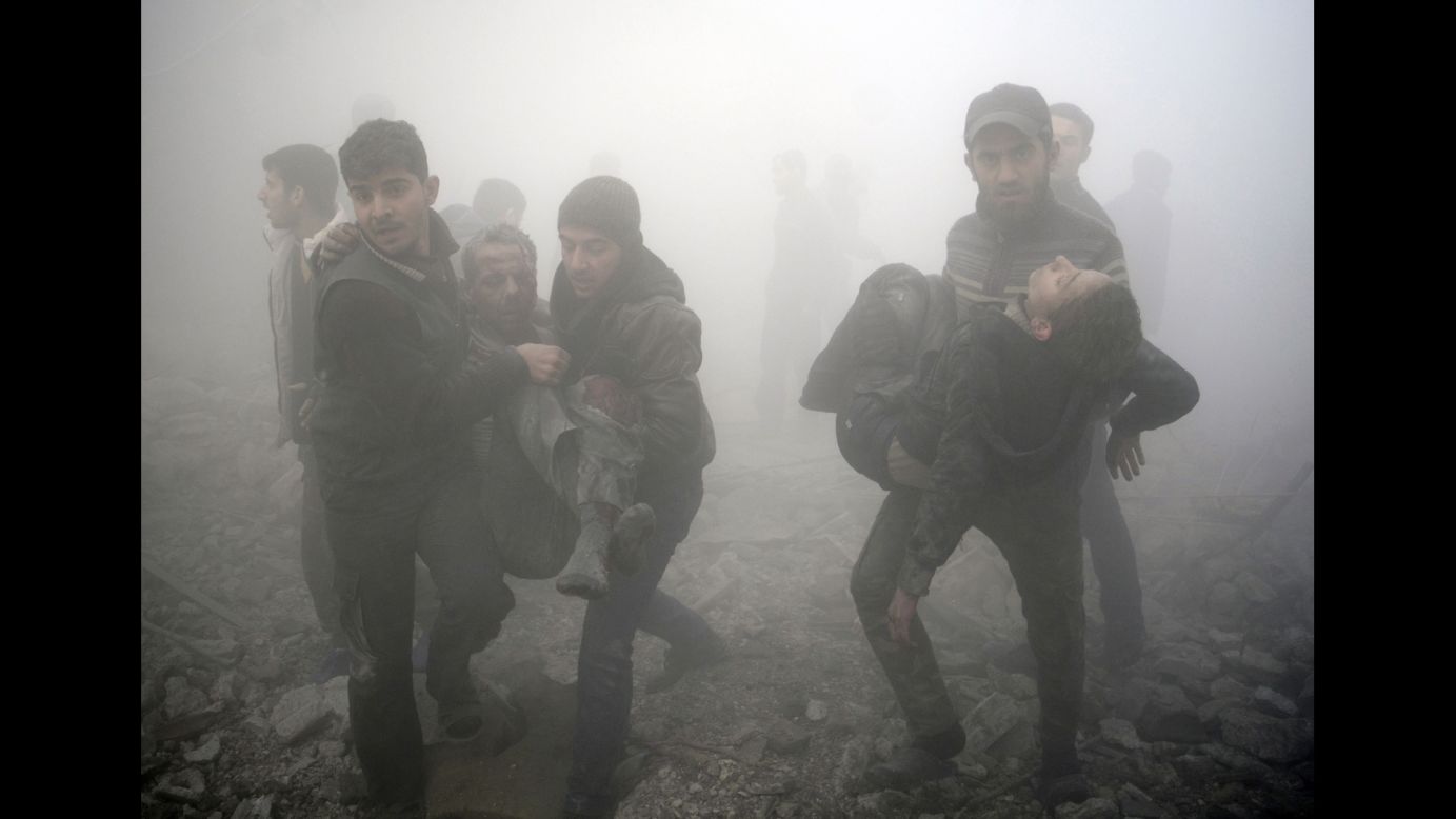 Syrian men carry wounded people after a reported airstrike on the rebel-held town of Douma, Syria, on Wednesday, January 21.