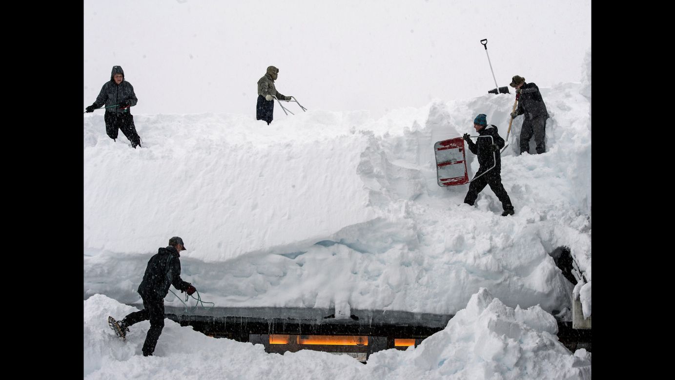 People remove snow from the roof of a hostel in Voss, Norway, on Friday, January 16.