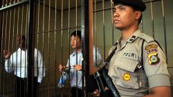 n Indonesian policeman stands guard next to a detention room where Australians Myuran Sukumaran (L) and Andrew Chan (C), members of the so called Bali Nine gang, wait for their trial in Denpasar on the island of Bali on October 8, 2010. An Indonesian prison chief testified on October 8, that two Australian drug smugglers on death row have given great contribution in teaching fellow inmates and should not be executed. Andrew Chan and Myuran Sukumaran, members of the so-called Bali Nine gang, are seeking 20 years to life in prison for a 2005 attempt to smuggle 8.3 kilograms (18 pounds five ounces) of heroin into Australia from Bali island. AFP PHOTO / SONNY TUMBELAKA (Photo credit should read SONNY TUMBELAKA/AFP/Getty Images)