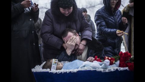 Vladimir Bovrichev cries next to the body of his 4-year-old son, Artiam, during Artiam's funeral on the outskirts of Donetsk on Tuesday, January 20. The boy was killed during a Ukrainian artillery strike.