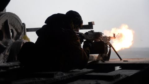 A Ukrainian volunteer fighter fires a machine gun at pro-Russian rebels near the village of Pisky, Ukraine, on Saturday, January 3.