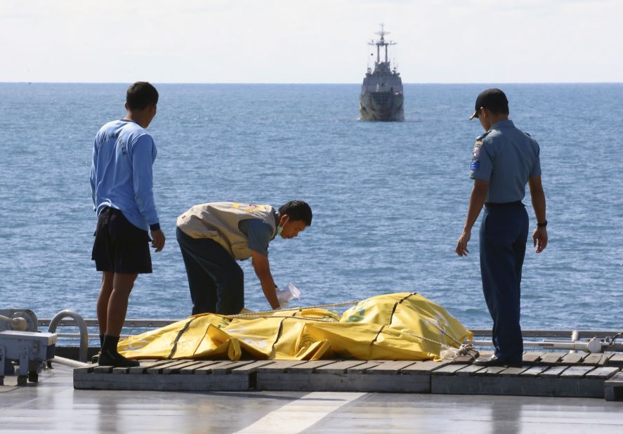 Crew members inspect body bags on the deck of a ship in the Java Sea on Friday, January 23. 