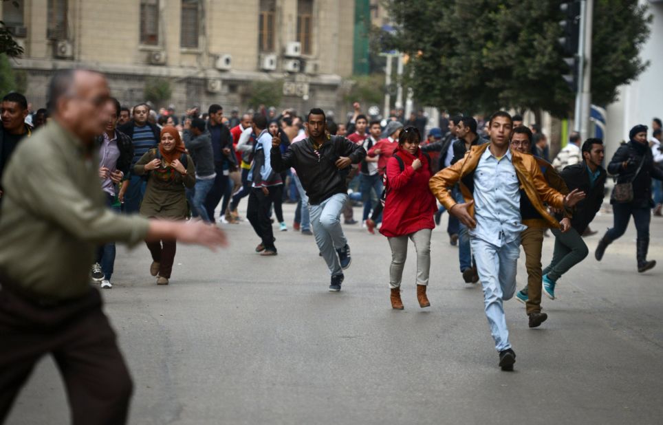 Opponents of Egyptian President Abdel Fattah el-Sisi run for cover during clashes with pro-government demonstrators on January 25 in Cairo. 