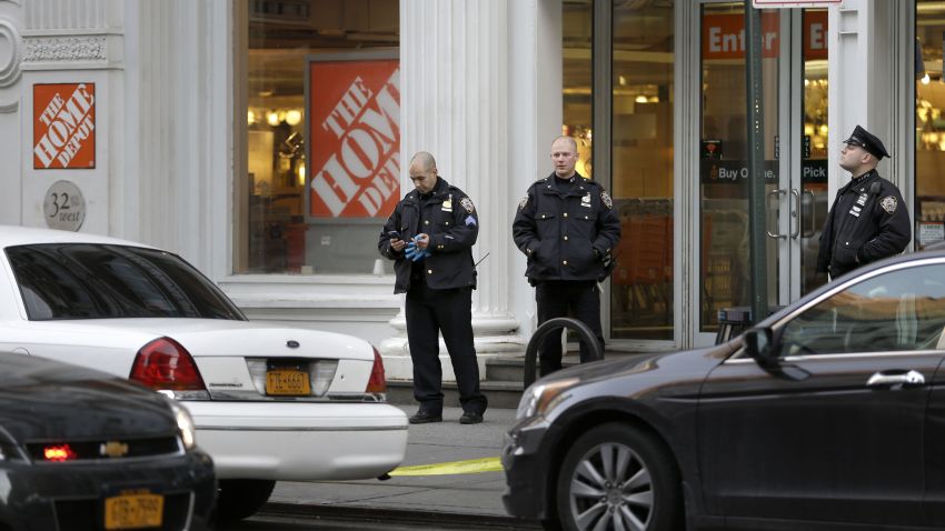 New York City Police officers stand in front of a Home Depot, Sunday, Jan. 25, 2015, in New York. Police said an employee at the store argued with a co-worker before fatally shooting him and then killing himself. (AP Photo/Seth Wenig)