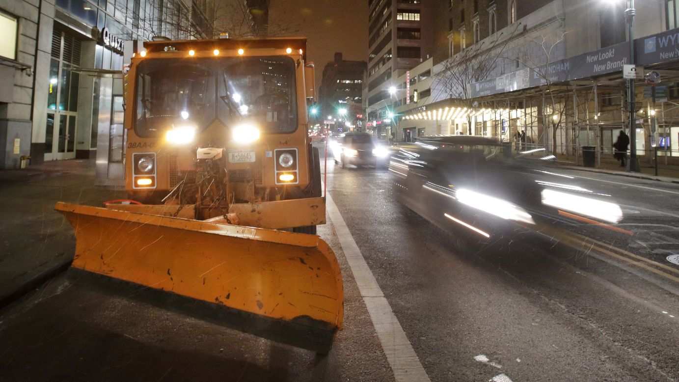 A New York City snowplow, loaded with salt, sits in midtown Manhattan as light snow falls on January 26.