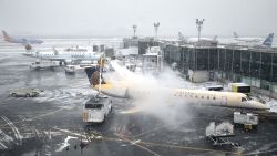 A plane is de-iced at LaGuardia Airport in New York, Monday, Jan. 26, 2015. Airlines canceled thousands of flights into and out of East Coast airports as a major snowstorm packing up to 3 feet of snow barrels down on the region. (AP Photo/Seth Wenig/AP)