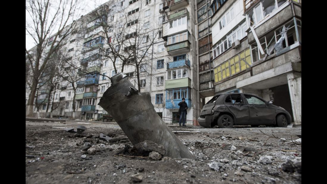 A piece of an exploded missile sits lodged in the ground outside an apartment building in the Vostochniy district of Mariupol on Sunday, January 25.