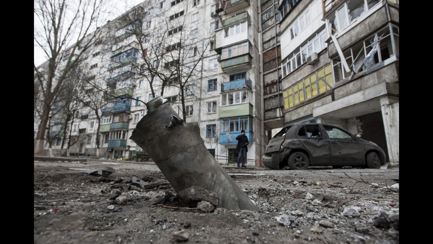 A piece of an exploded missile sits lodged in the ground outside an apartment building in the Vostochniy district of Mariupol on Sunday, January 25.