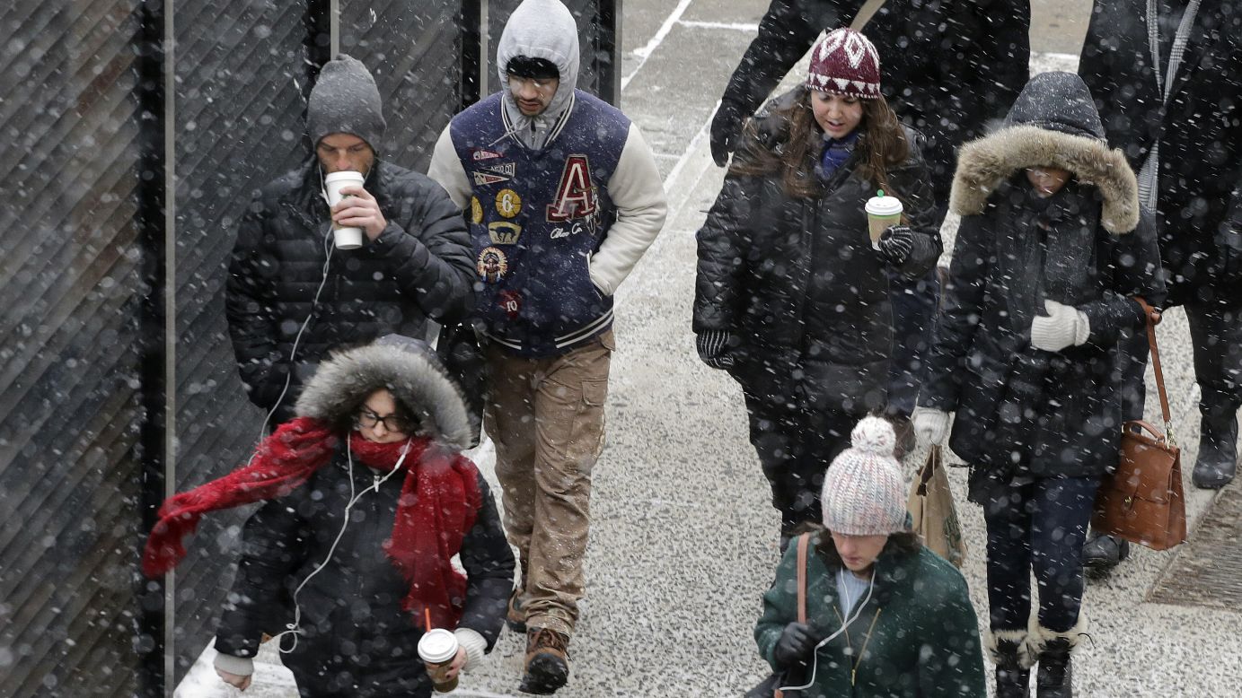 Snow falls on pedestrians in New York on January 26.