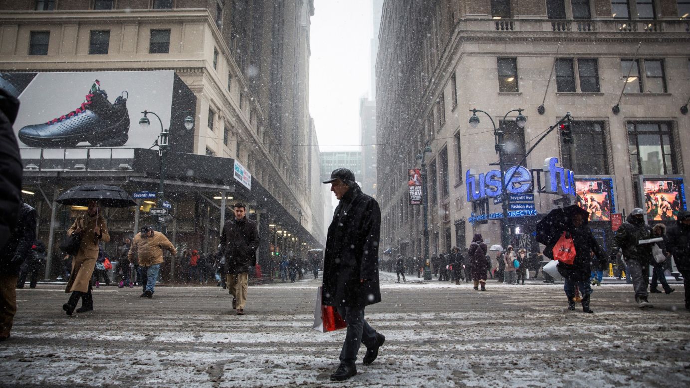 People walk near Penn Station on New York's Seventh Avenue while a major snowstorm begins on January 26. 
