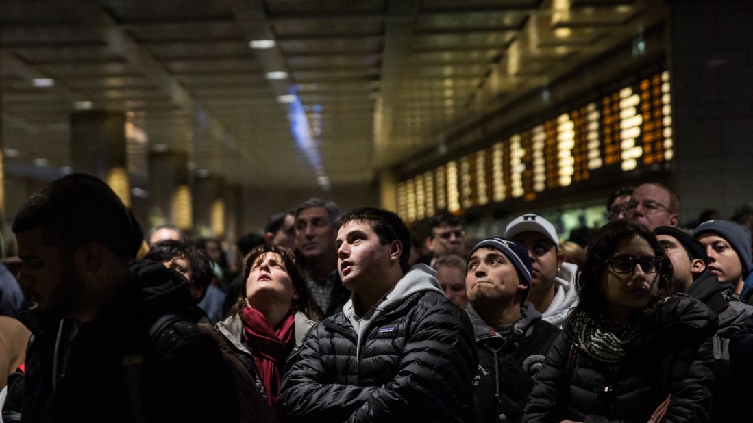 Travelers wait for their train platform to be announced at New York's Penn Station on January 26.