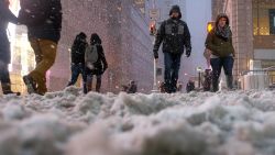 People cross a street covered in snow in New York's Times Square during a snow storm on January 26, 2015. A winter storm pounded the northeastern United US on January 26 hitting tens of millions of people and forcing the rare cancelation of Broadway shows in an "historic" New York blizzard. Winter Storm Juno is expected to dump up to three feet (around a meter) of snow in parts of the northeast, with the worst affected areas likely to be New England, particularly Connecticut and Massachusetts. More than 6,560 flights on Monday and Tuesday were cancelled, the New York city transit system was to shut at 11pm and road travel made a criminal offense in 13 counties of New York state. AFP PHOTO/JEWEL SAMAD        (Photo credit should read JEWEL SAMAD/AFP/Getty Images)