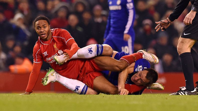 Liverpool's Raheem Sterling, left, and Chelsea's John Terry get tangled up during a League Cup semifinal match Tuesday, January 20, in Liverpool, England. Sterling scored a goal in the match as the two teams tied 1-1.