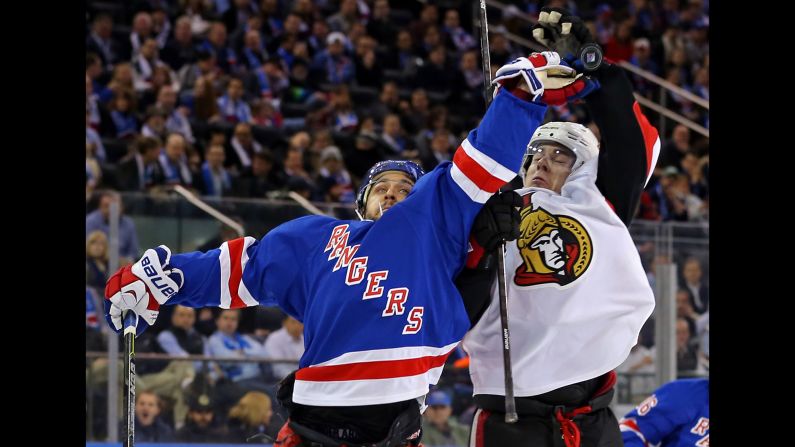 Mats Zuccarello of the New York Rangers, left, and Jean-Gabriel Pageau of the Ottawa Senators reach for a puck during an NHL game in New York on Tuesday, January 20.