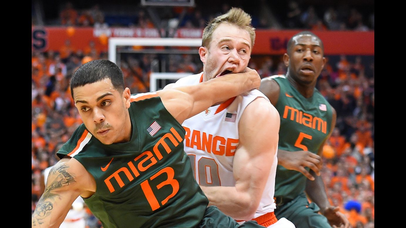 Syracuse guard Trevor Cooney is hit in the face by Miami guard Angel Rodriguez while he drives to the basket Saturday, January 24, in Syracuse, New York.