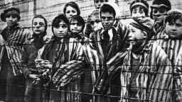 Children behind a barbed wire fence at the Nazi concentration camp at Auschwitz in southern Poland. (Photo by Keystone/Getty Images)