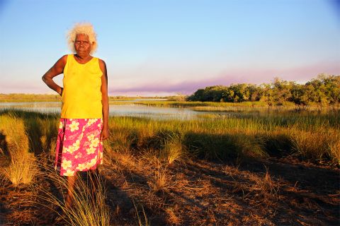 Peace Woolla stands in front of a lake on Wik homelands, Far North Queensland.