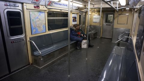 Two passengers ride a subway car in New York on January 26.