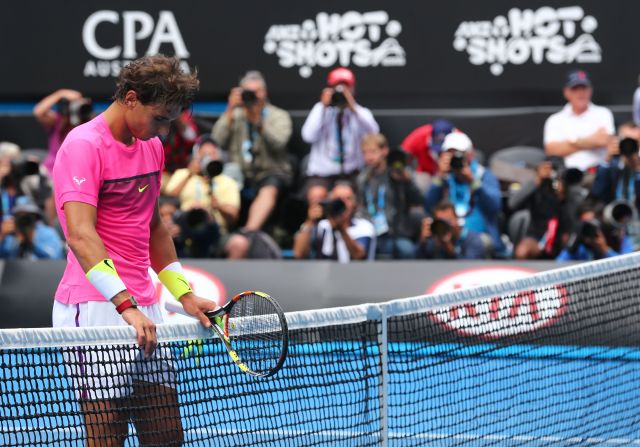 A dejected Rafael Nadal waits to shake hands at the net with Tomas Berdych.