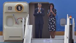 U.S. President Barack Obama and first lady Michelle Obama fold their hands together in a traditional Indian greeting gesture as they prepare to board Air Force One in New Delhi, India, January 27, 2015.