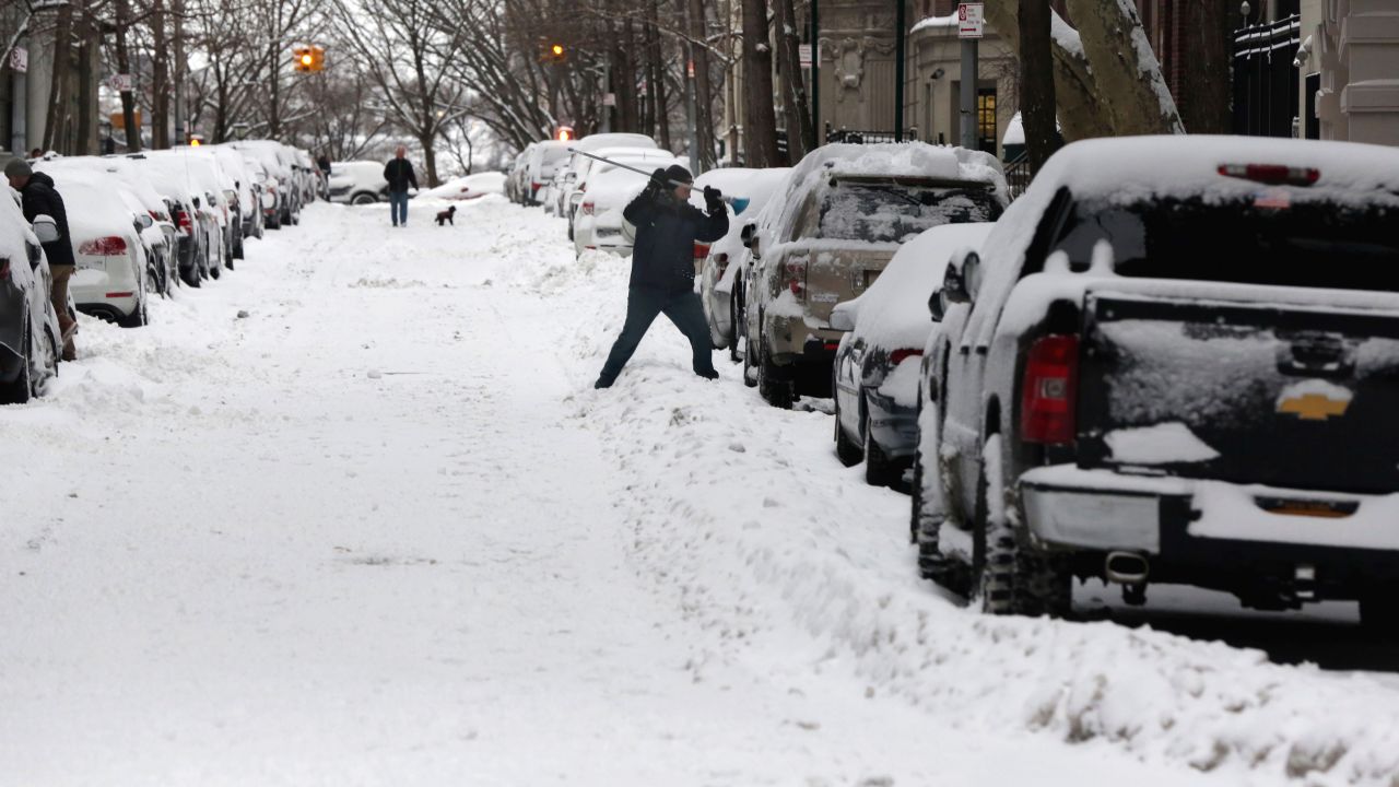 A man clears his snow-covered car on the Upper West Side in New York City on January 27.