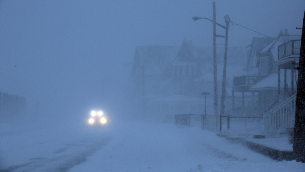 An emergency vehicle drives down a snowy street in Winthrop, Massachusetts, on January 27.
