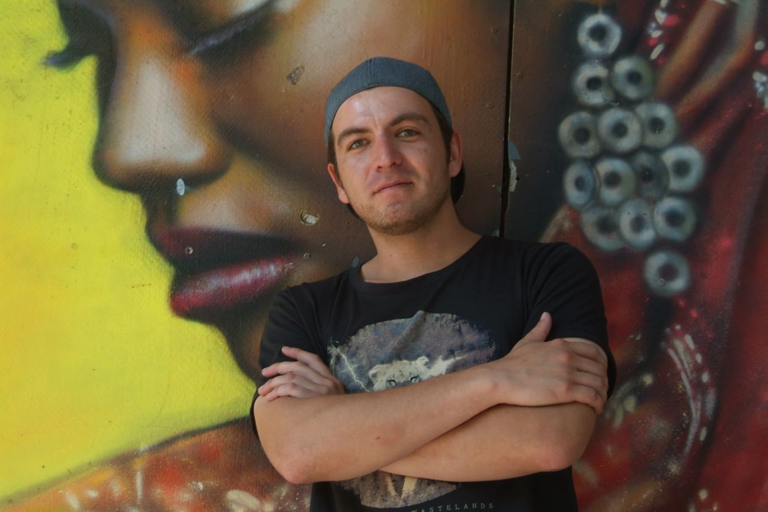 Alan Zarate, seen here in front of a mural he created, is one of a growing number of artists taking advantage of the new demand for street art.
