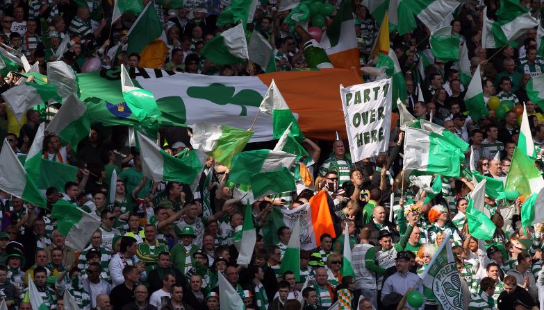 Celtic fans wave flags and an Irish tricolor at an Old Firm game at Ibrox Stadium in 2012. Historically, Celtic has been the club of Glasgow's Irish Catholic diaspora while Rangers the club of the city's majority Protestant population.