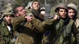 Israeli soldiers carry an injured soldier Wednesday on the border with Lebanon.