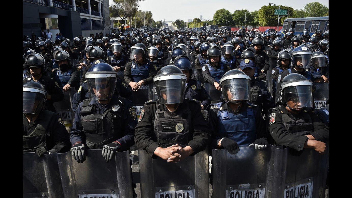 Hundreds of police officers in riot gear block a street during several marches in Mexico City on January 26.
