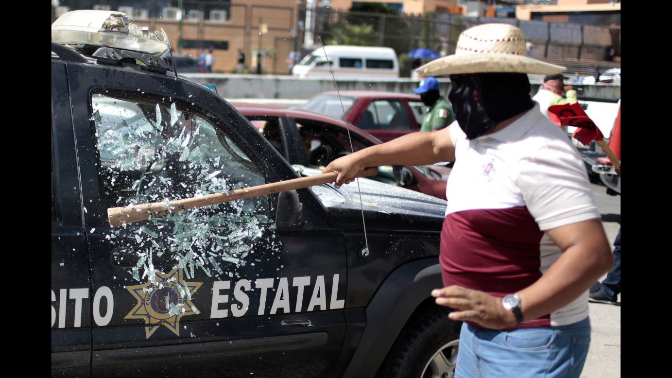 A man smashes the window of a traffic patrol vehicle during a protest in Chilpancingo, Mexico, on Thursday, January 15.