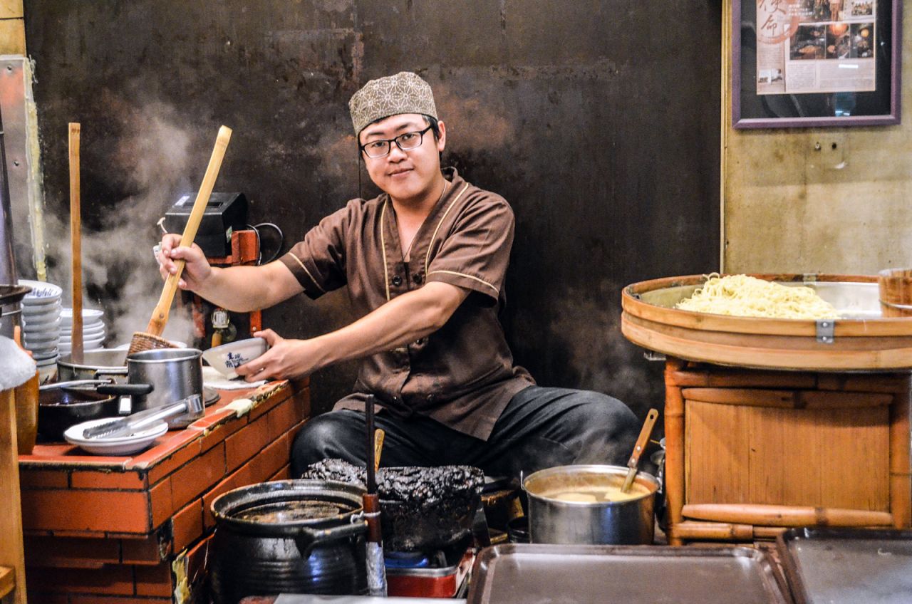 Danzai noodles were originally sold out of buckets on a bamboo pole slung over a shoulder. Today, a chef in Du Xiao Yue cooks up noodles while seated on a stool.