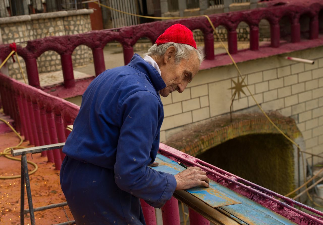Gallego had no formal architecture training or construction experience when he began working on the project more than 50 years ago. Here, he cuts tin to be used in the roof of his his cathedral.
