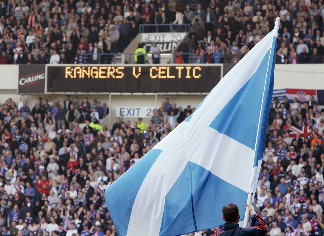 A Scottish saltire is waved before an Old Firm game at Ibrox.