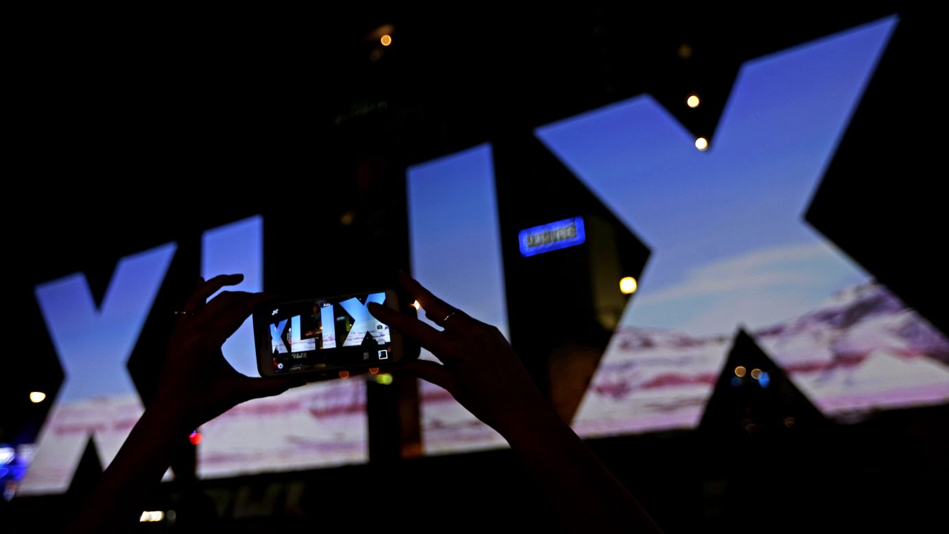 A woman takes a photo of Roman numerals for Super Bowl XLIX Wednesday, Jan. 28, 2015, in downtown Phoenix. The New England Patriots face the Seattle Seahawks in Super Bowl XLIX on Sunday in Glendale, Ariz. (AP Photo/Charlie Riedel)