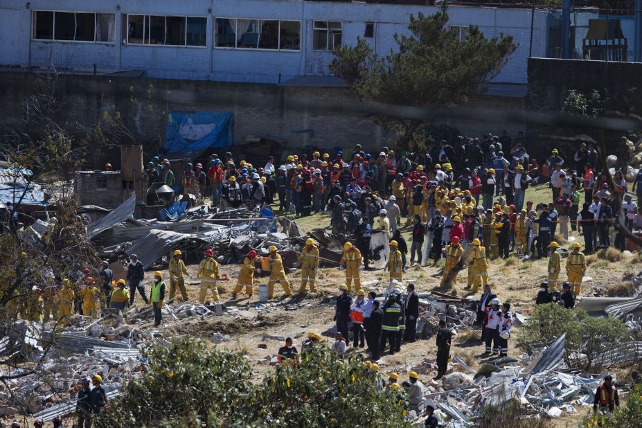Rescue workers form a human chain as they clear wreckage following the explosion. 