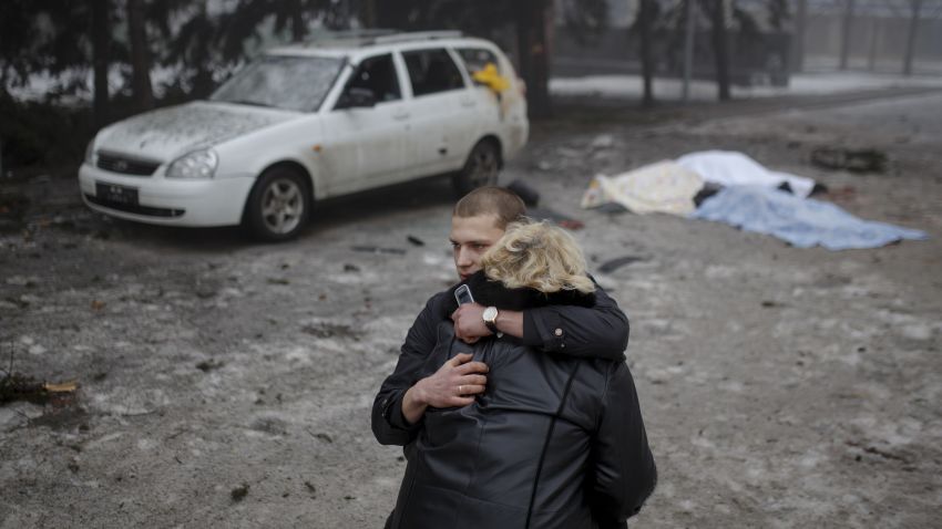 A rebel comforts a wife of a killed civilian in shelling in Donetsk, eastern Ukraine, Friday, Jan. 30, 2015. Artillery fire in the rebel stronghold of Donetsk killed at least 12 civilians on Friday afternoon, the city hall in the rebel stronghold said, as fighting intensifies between pro-Russia separatists and government troops. (AP Photo/Vadim Braydov)