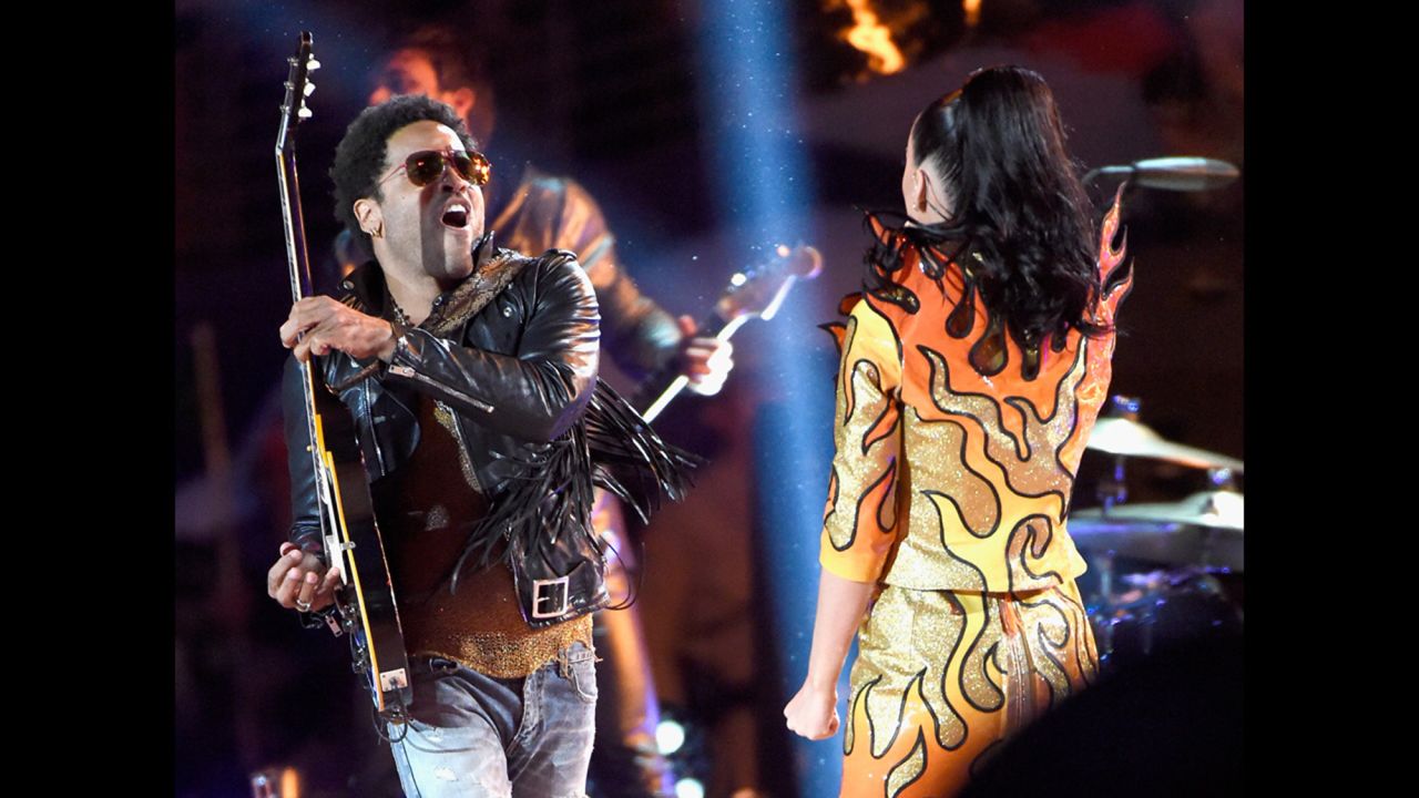 Lenny Kravitz plays the guitar on stage with Perry as she sings "I Kissed a Girl."