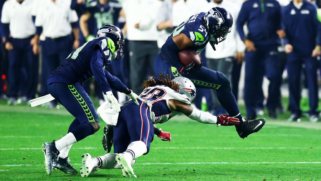 Seattle linebacker Bobby Wagner, right, runs the ball after intercepting Brady in the third quarter. The turnover set up Baldwin's touchdown drive.