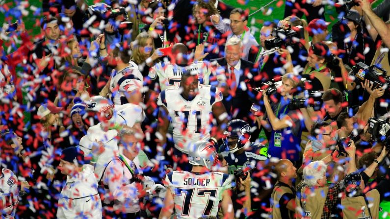 Patriots owner Robert Kraft, at center in the red tie, congratulates defensive tackle Vince Wilfork.