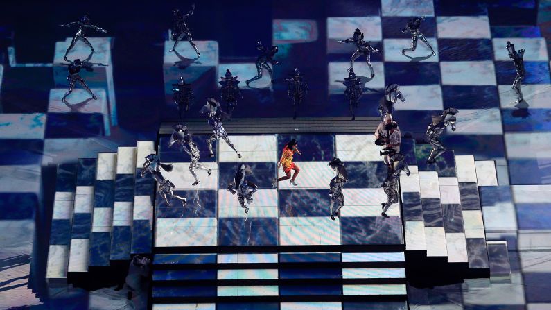 Perry performs on a checkerboard projected on the floor.