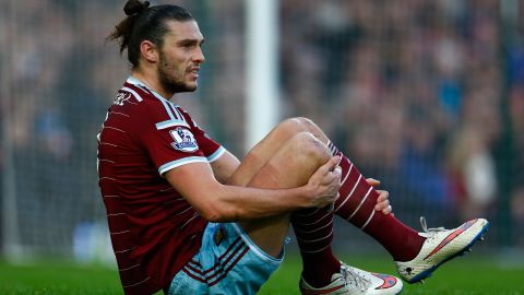 Andy Carroll of West Ham United grimaces as he hits the turf in a Premier League game against Arsenal in 2014.