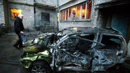 A man stands next to his car in Donetsk on Sunday, Febuary 1, after it was destroyed by shelling.