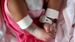 Editors Note: This image may have been digitally manipulated for confidentiality to remove any patient identity data. A newborn baby girl wears an electronic tag as she sleeps in her cot in the maternity unit of Birmingham Women's Hospital on January 22, 2015 in Birmingham, England.