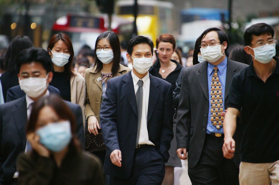 In 2003, Severe Acute Respiratory Syndrome (SARS) became a global pandemic, infecting over 8,000 people worldwide and causing the death of 774. Pictured, people wear surgical masks to try to reduce the chance of infection from SARS whilst walking through the business district April 1, 2003 in Hong Kong.