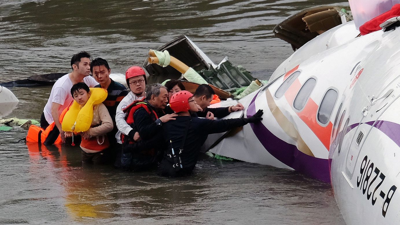Rescue personnel assist passengers as they wait to be transported to land on February 4.