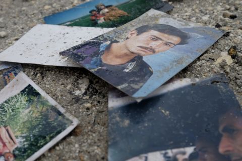 Photographs of civilians are seen on a street outside of a destroyed house on Saturday, January 31.