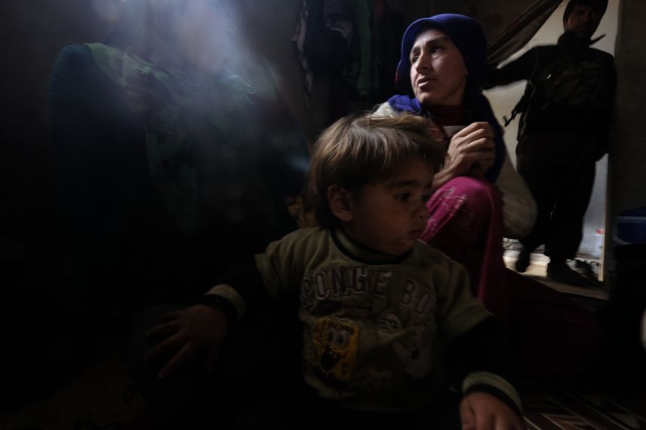 Zehra, a 25-year-old Kurdish woman who lost her 8-month-old daughter due to a lung infection at a refugee camp, sits with her other daughter inside their home in Kobani, Syria, on Thursday, January 29. Her husband, a fighter from the People's Protection Units, or YPG, stands in the background. After four months of intense fighting, Kurdish Peshmerga forces <a href="http://www.cnn.com/2015/02/04/middleeast/kobani-syria-destruction/index.html" target="_blank">have liberated Kobani</a> from the grip of the ISIS militant group. Click through to see more photos of Kobani taken recently by Ricardo Garcia Vilanova.