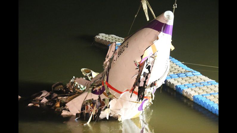 The plane's mangled fuselage gets pulled to the riverbank February 4.